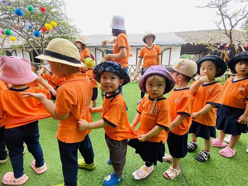 Mũ đồng phục mầm non nên có phần dây rút hoặc quai cài để cố định